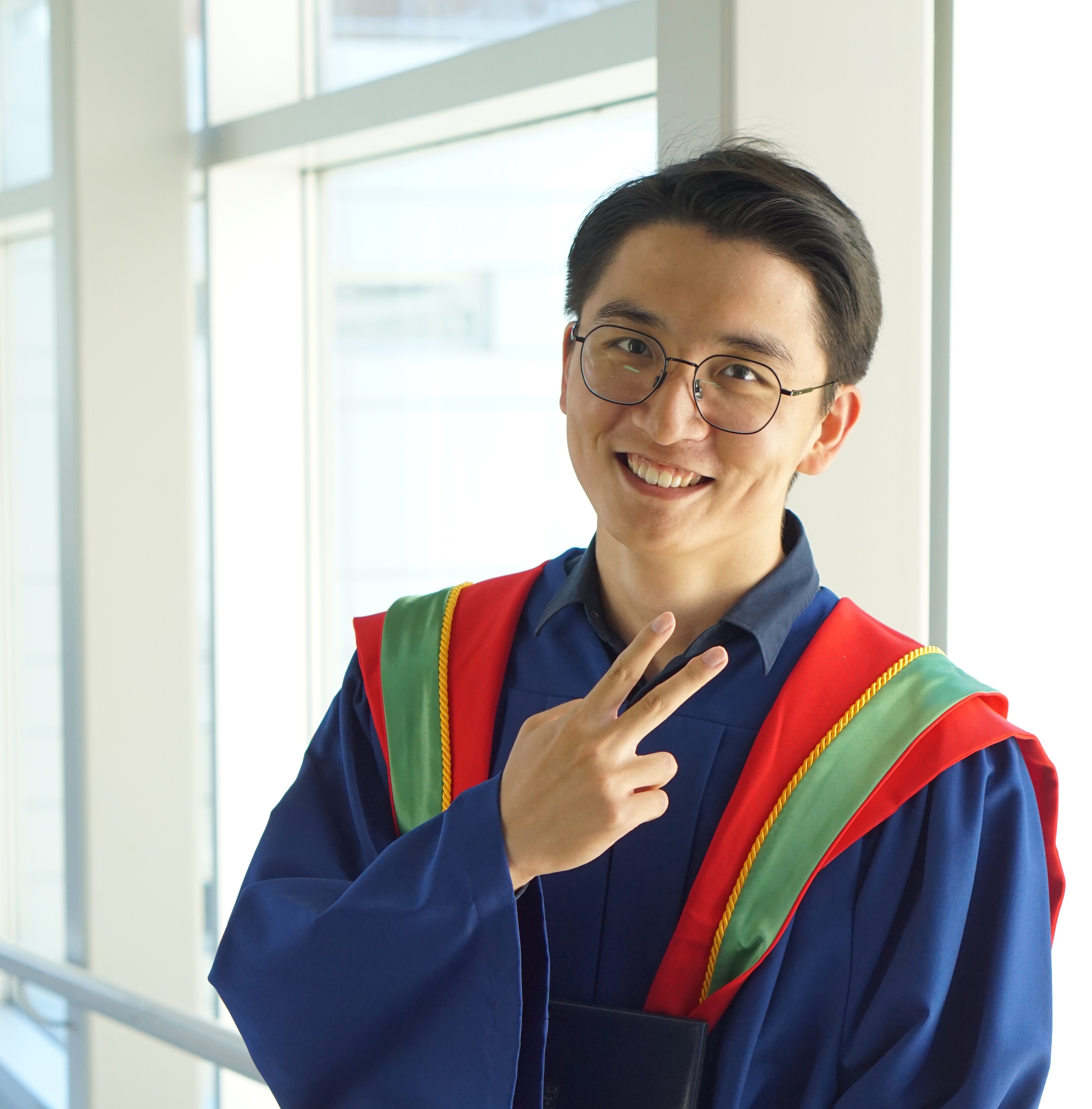 Dujian Ding smiling in graduation attire